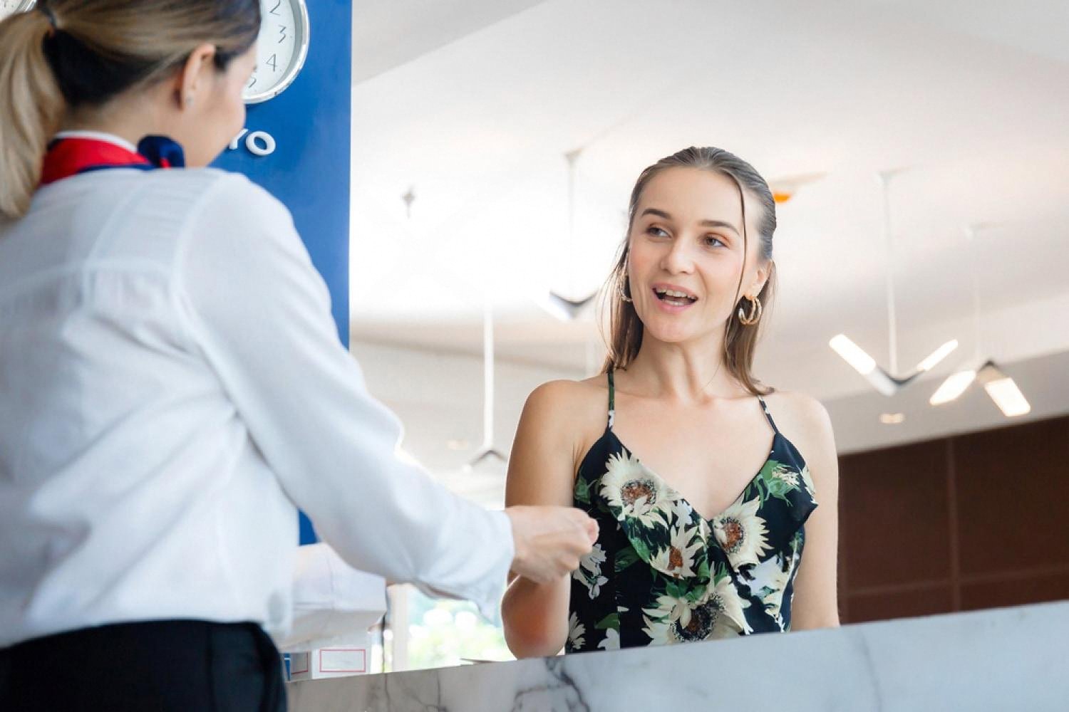 Guest checking in at a hotel reception desk with a receptionist in the UAE